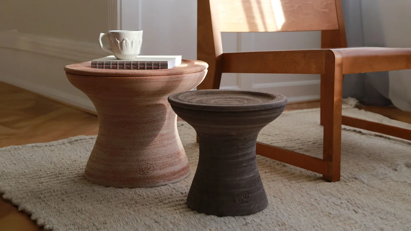 Rosa and Grey Celeste terracotta vessels used as pedestals beside a chair.